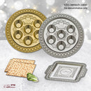 A round, silver-colored plastic Seder plate with an ornate embossed border, six labeled indentations for Seder foods, and a central cup for bitter herbs.