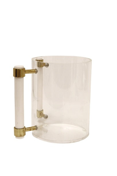 A transparent cylindrical container with a white and gold handle attached to the side. Inside the container, there is a vertical white rod secured by gold fittings at the top and bottom. The container has a minimalist and modern design, resembling a pitcher or measuring vessel.