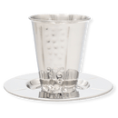 A silver stainless steel Kiddush cup with a hammered texture on the sides, sitting securely on its matching circular saucer tray.