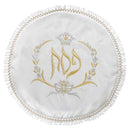 A round, white matzah cover with intricate embroidery. It has gold and silver threads showing Hebrew text and six small circles with more Hebrew words. The edge is decorated with a ruffled gold and silver trim.