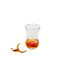 A LAV 4oz Turkish tea glass with a traditional curved shape, partially filled with amber-colored tea, set against a neutral background with an orange peel garnish.