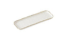 A long, narrow, rectangular white porcelain serving tray with a gold-trimmed, irregular raw edge.