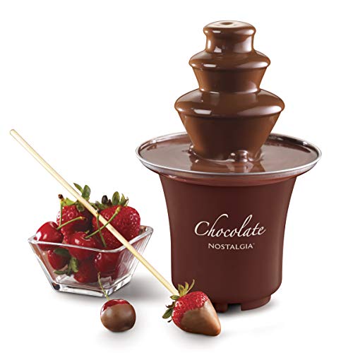 Chocolate fondue fountain displayed with strawberries and a dipping skewer