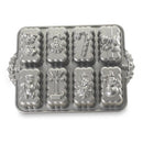 Nordic Ware silver holiday mini loaves pan with eight festive mold designs on a white background.