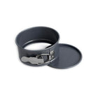 A small, round, metallic nonstick springform pan with a quick-release latch and a separate removable bottom.