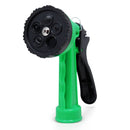 Close-up front view of a green and black garden hose spray nozzle with multiple spray pattern settings labeled on the dial, including options like shower, flat, and cone.