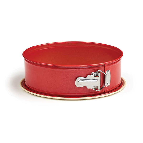 Side view of a 9-inch red springform pan with a metal latch and beige nonstick base.