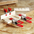 Clamps holding multiple boards in a woodworking setup
