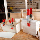 Three clamps used in DIY wood projects on a workshop bench