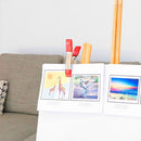 Clamp holding artwork on easel in living room setup