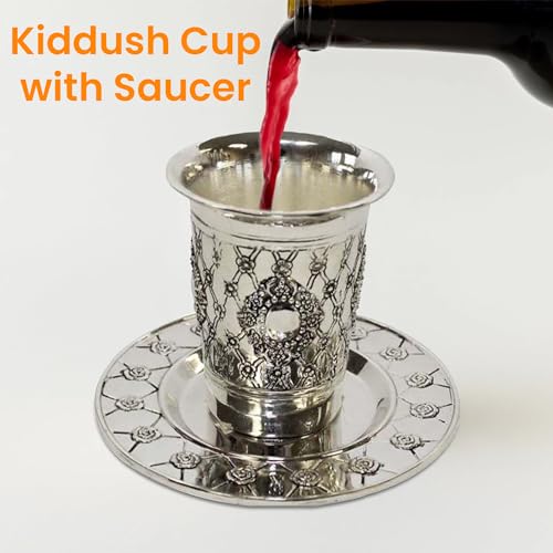 Silver Kiddush cup with ornate detailing and saucer, with wine being poured inside (used for reference display).