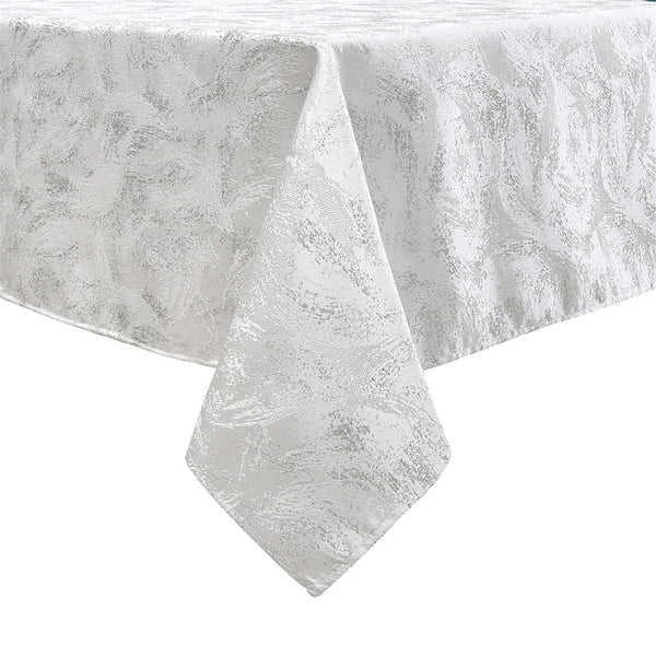 White tablecloth with a subtle floral pattern, elegantly draped over a table, showcasing its textured fabric.