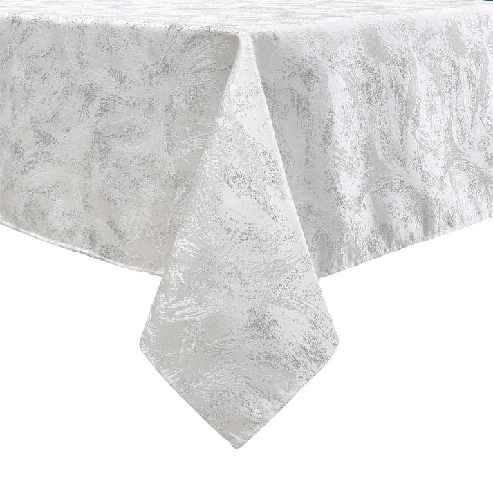 White tablecloth with a subtle floral pattern, elegantly draped over a table, showcasing its textured fabric.