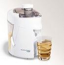 Hamilton Beach white juice extractor with glass of fresh juice beside it