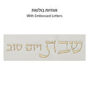 Close-up of embossed Hebrew letters "Shabbat VeYom Tov" on challah cover