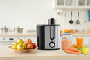 Courant juicer on a kitchen counter with fresh fruits and juice