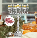 Silver menorah with Ner Mitzvah refill wicks on a festive table setting.