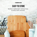 Bamboo cutting boards stored upright among kitchen tools.