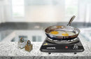 Black Courant burner in a kitchen setting with a frying pan cooking eggs on top.
