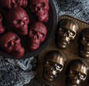 red Skull cakes in a brown bowl beside Nordic Ware bronze skull-shaped cakelet pan