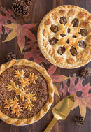Pies cut using the Red Nordic Ware reversible pie top cutter with apple design on one side and leaf design on the other, shown on a white background.