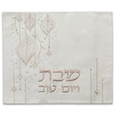 Faux leather challah cover in light neutral tone featuring embossed hanging ornament design and Hebrew Shabbat greeting