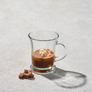 Clear 13-ounce glass mug with handle, shown holding a hot beverage with foam on top