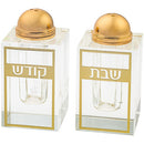 Salt shakers that say shabbos and kodesh on a white background