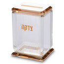 Clear crystal tzedakah box with gold Hebrew lettering and gold-accented base and lid