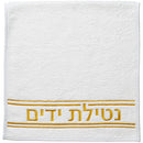 White hand towel with gold embroidery that says 'netilas yadayim'