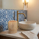 Beige lucite wash cup on a bathroom counter next to a sink