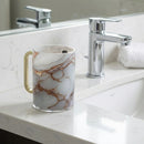 Lucit washing cup with a marble design on a bathroom counter next to a sink