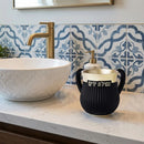Black and gold polymer washcup on bathroom counter next to a sink