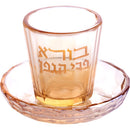 Clear and gold kiddush cup with a  saucer on a white background