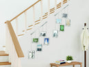 A modern silver photo display featuring five square frames hanging from a horizontal bar by thin rods.