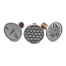 Set of three Nordic Ware honeybee-themed cast aluminum cookie stamps with wooden handles, arranged on a white background.