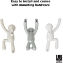 Set of three grey Umbra Buddy wall hooks shaped like climbing figures, designed for hanging items, shown mounted on a white background.