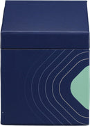 A lighted, white scented candle in a clear glass votive, positioned next to its dark blue, house-shaped packaging box. The box features the "TRAPP FRAGRANCES" logo in gold, and a label indicating "No. 13 BOB'S FLOWER SHOPPE™" with scent notes of "FRESH FLORALS, CUT GREEN STEMS, WATERY ACCORDS." The candle is a "FRAGRANCED CANDLE 7 oz | 198g ℮".
