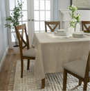 Close-up of a rectangular tablecloth in a light beige, linen-like textured polyester fabric, draped over a corner.

