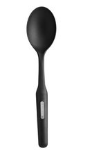 A black Farberware solid cooking spoon, made of nylon with a matte finish on the spoon head and a slightly glossy ergonomic handle with a silver Farberware logo.