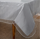 A Home Details Crystal Clear Tablecloth Protector is shown draped over a silver tablecloth, highlighting its durable clear plastic and spill-proof table protection.