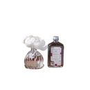 A clear glass bottle of Brambleberry reed diffuser oil with a silver screw-on cap. The bottle has a decorative pink and white label with illustrations of berries and leaves.