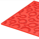 Lodge 7-inch red silicone hot pad and trivet, heat resistant, non-slip, featuring a textured cast iron pan design.
