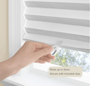 White pleated window shade with a cordless, easy-to-install design, featuring a clear plastic clip for adjusting the length. The durable, light-blocking material provides privacy and room darkening, making it ideal for bedrooms, offices, and living spaces.