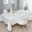 White and silver jacquard tablecloth spread over a medium dining table