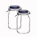 Two empty, clear glass Fido jars, each with a dark blue plastic lid insert and a metal wire clamp closure.