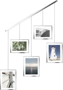 A modern silver photo display featuring five square frames hanging from a horizontal bar by thin rods.