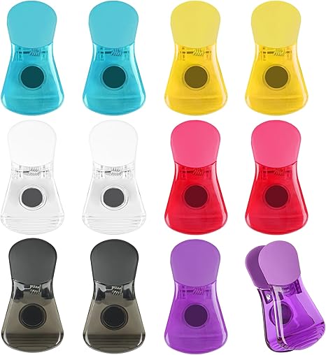 Set of 12 colorful magnetic clips in assorted colors, including blue, yellow, clear, red, black, and purple. Each clip features a strong round magnet on the back and a sturdy plastic grip, ideal for securing papers, bags, or notes to magnetic surfaces.