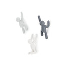 Set of three grey Umbra Buddy wall hooks shaped like climbing figures, designed for hanging items, shown mounted on a white background.