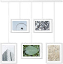 A contemporary white photo display featuring five square frames suspended from a horizontal bar by thin rods.